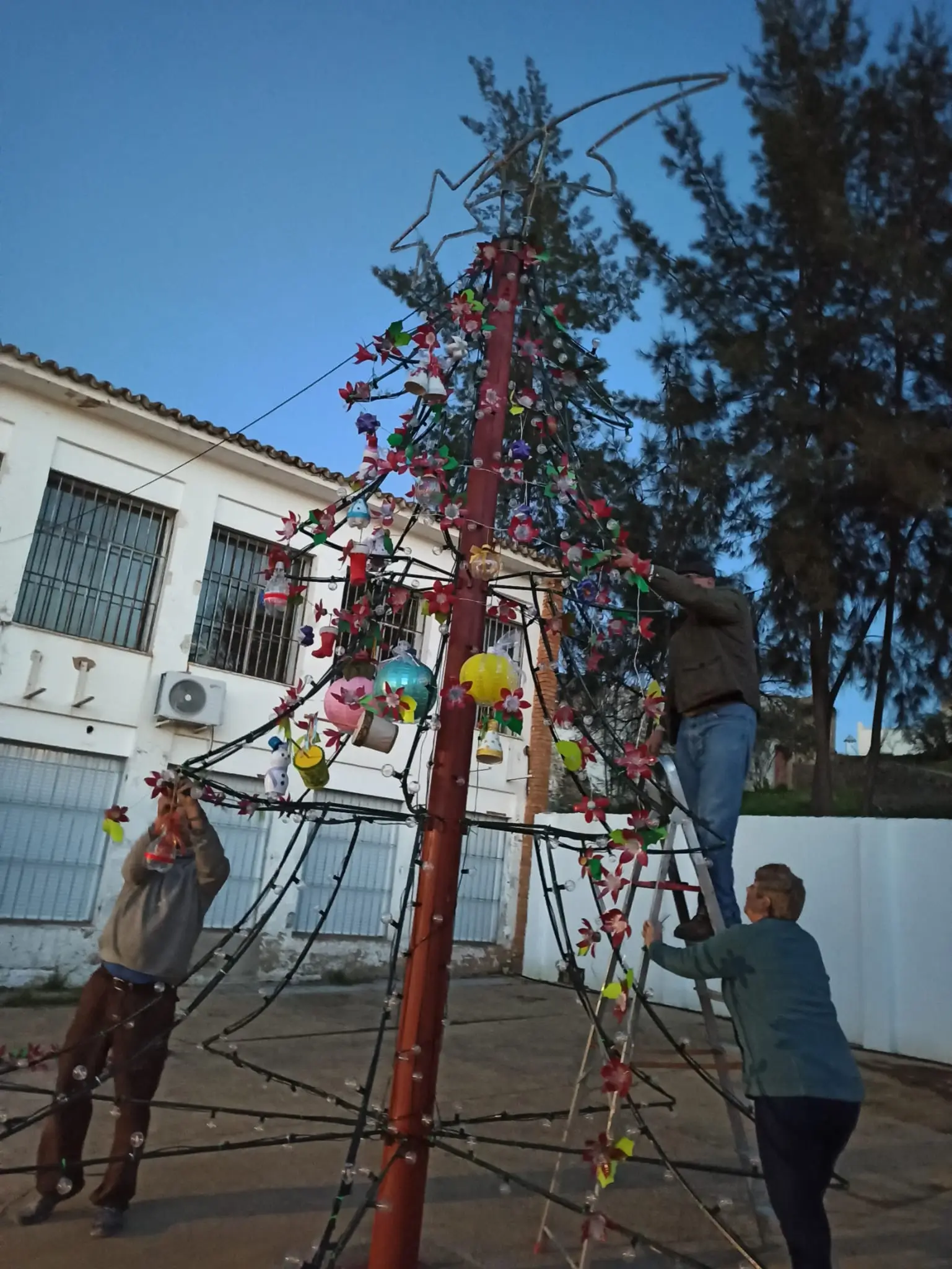 Imagen de directiva y socios adornando arbol de navidad con manualidades